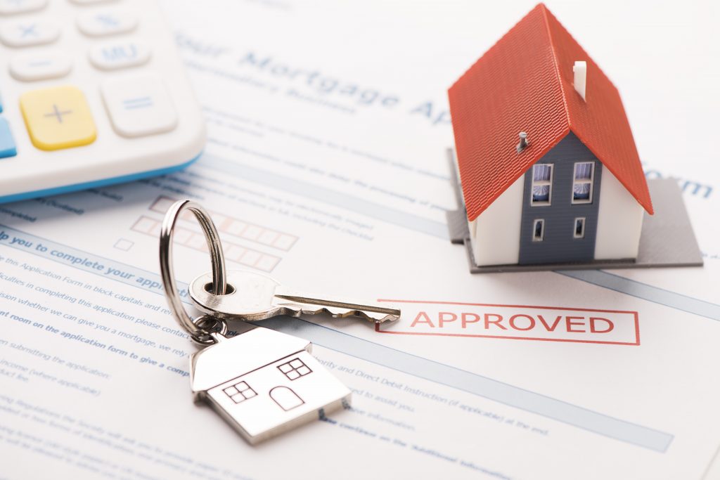 Keys and model house on an approved mortgage application